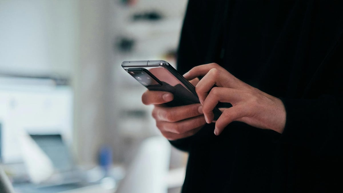 Henkilö käyttämässä mobiililaitetta ja tarkistamassa kierrätysvaatimuksia Pafilla