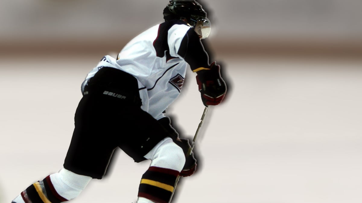 Jääkiekkoilija pyyhkäisee jään poikki tärkeässä ottelussa.