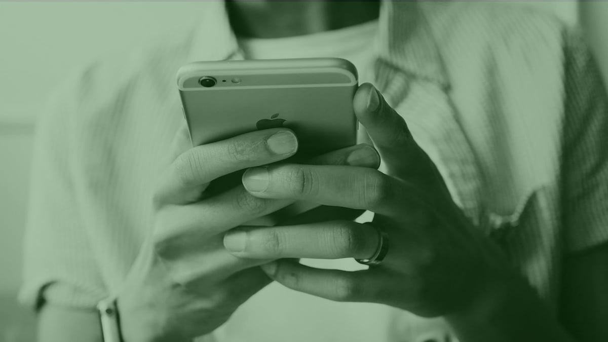 Henkilö, joka kokeilee uusia ja eksklusiivisia kolikkopelejä puhelimellaan.