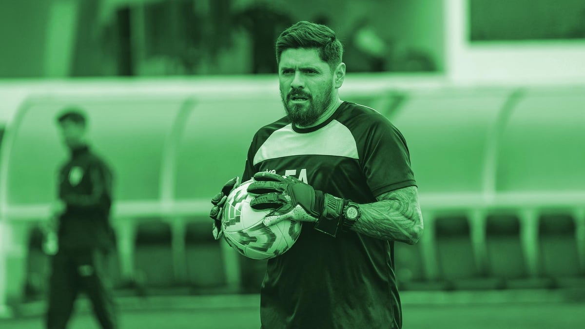 Maalivahti pitelee jalkapalloa ja näyttää vakavalta.