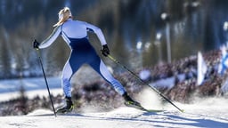 Naishiihtäjä kilpailee talviolympialaisissa lumisessa maisemassa.