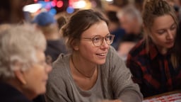 Bingopeli käynnissä, pelaajia keskittyneenä pelipöydän ääressä