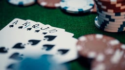 Pokerikäsi pöydällä, kortit ja pelimerkit esillä kasinotilanteessa.